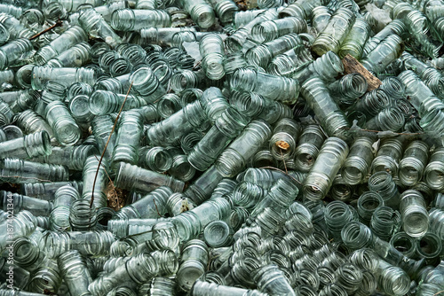 Empty glass sauce jars (industrial glass container) piled high, production has stopped, production slump, non returned empties concept. Jars background