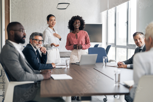 Photos Diverse business team collaborating and listening during meeting