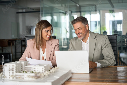 Tableau sur toile Real estate developers working on laptop discussing new residential or commercial development construction project at meeting