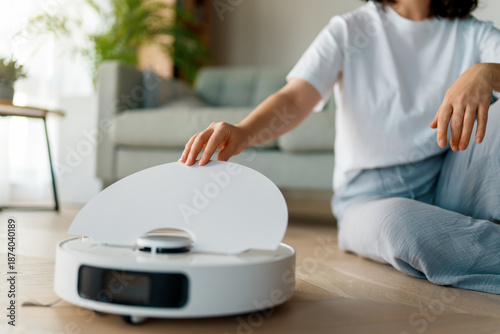 Foto White robotic vacuum cleaner on wooden floor