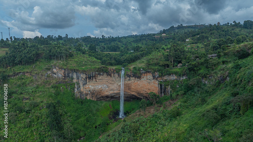 Wallpaper Mural Aerial view of the majestic Sipi Falls plummeting from rugged cliffs into a lush, verdant landscape under a dramatic sky, Sipi, Eastern Region, Uganda. Torontodigital.ca