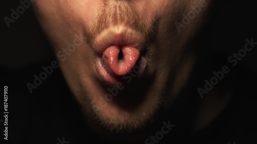 A man who has cowered aggressively moves his tongue.
An indecent tongue gesture.
A man teases and sticks out his tongue at the camera.