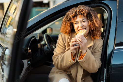 Foto Woman enjoying a quick meal in her car, having a fast food snack on the go