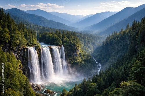 Magnificent waterfalls dropping over forested valley framed by expansive blue mountain ranges