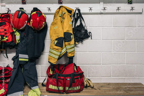 Firefighter equipment hanging in fire station locker room