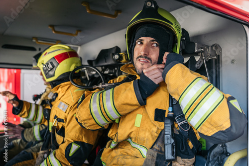 Fotografija Firefighters preparing for emergency inside firetruck