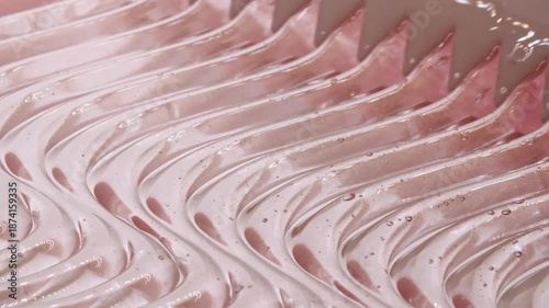 Transparent pink skincare cosmetic gel texture footage. Moisturising waves cream texture motion with spatula. Body care light creamy beauty product smudge closeup. Advertisement of a cosmetic product.