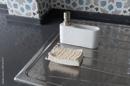 Eco-friendly kitchen cleaning setup with soap dispenser and natural cleaning dish sponge. Zero waste lifestyle