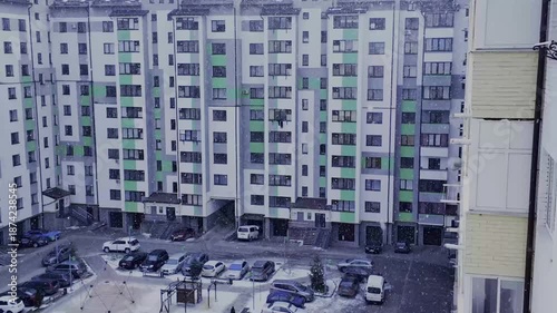 Light snowfall in the city. A residential complex and   large yard on a winter day.