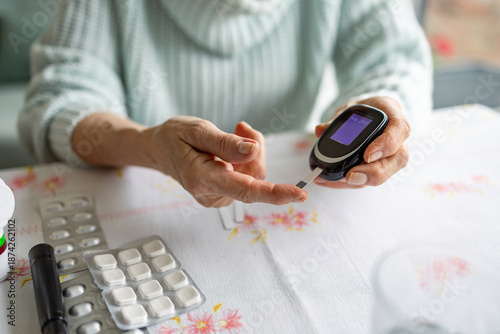 Canvas Print Senior Woman Checking Her Blood Sugar Levels by Glucose Meter at Home