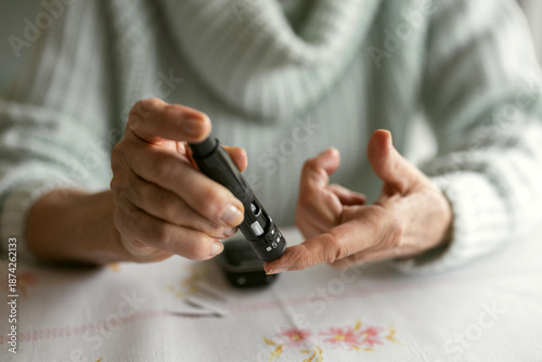 Tableau sur toile Senior Woman Checking Her Blood Sugar Levels by Glucose Meter at Home