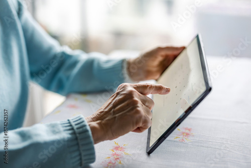 Senior woman using digital tablet at home
