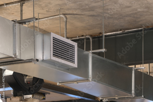 Принти на полотні Metal HVAC ventilation duct suspended from a concrete ceiling, showing industrial air distribution system inside a modern building