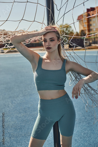 Fotografie Sportive young woman enjoys exercising outdoors under the bright spring sun