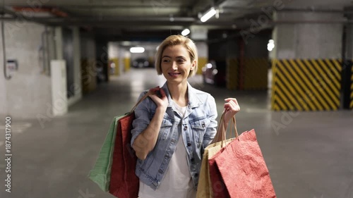 A smiling woman with shopping bags is happy after a successful shopping trip