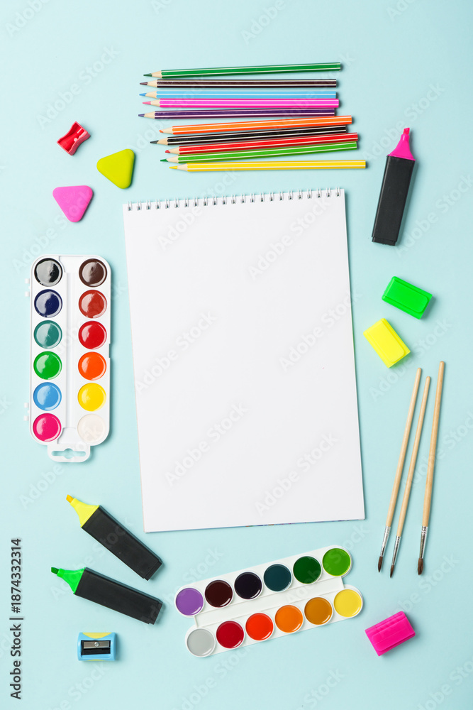 Naklejka premium Sketch book, markers, watercolor paints and pencils on blue background. Art creative composition with space for text.
