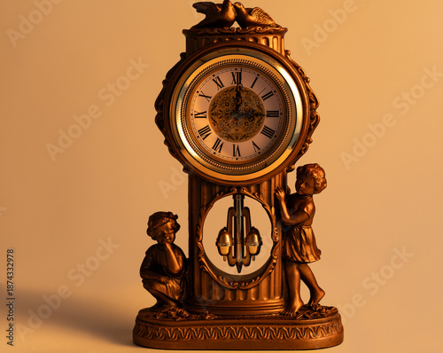 A bronze mantel clock with cherub figures at its base is illuminated by warm light.