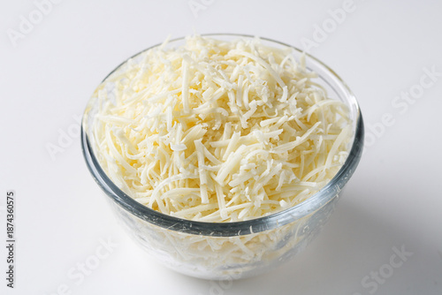 Photography Bowl of shredded cheese displayed in a clear glass bowl on a clean white background