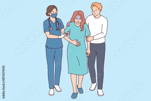 Young woman suffering from acute intestinal pain receives support from her husband and a nurse in a medical corridor. Healthcare professionals and family provide help during an emergency.