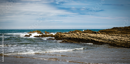 itzurun beach or zumaia beach in spain with blue sky