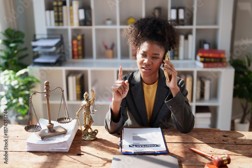 Slika na platnu Young African American female lawyer communicating on smartphone while explainin