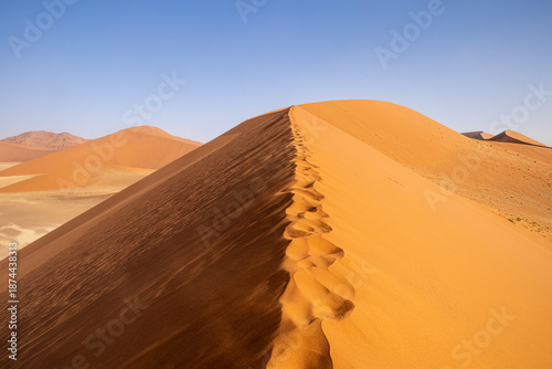 Majestic sand dune in Namibian desert under blue sky