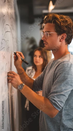 Wallpaper Mural Confident male employee collaborates during a business meeting, sharing strategies on a whiteboard. Contemporary workspace atmosphere highlights innovation and productivity Torontodigital.ca