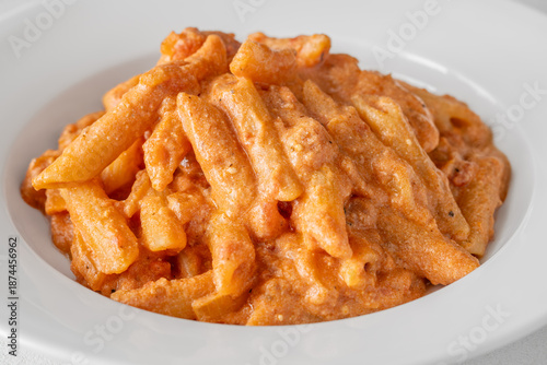 Penne pasta in creamy ricotta tomato sauce with grated parmesan cheese