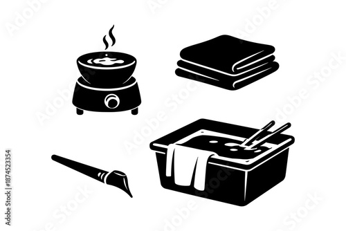 Black and white spa objects: wax warmer, towels, hot stone bath, spatula