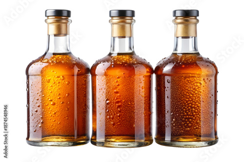 Three amber glass bottles of rum with condensation droplets, isolated on a clean white background, studio shot