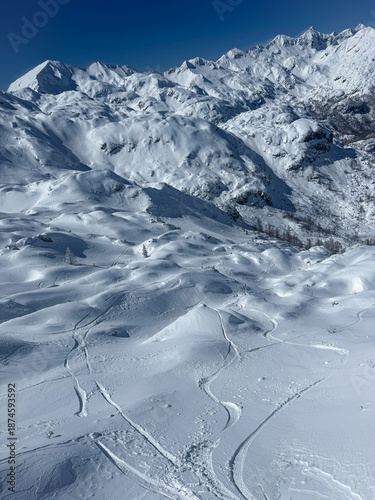 Φωτογραφία Rolling alpine ridges and bowls blanketed in fresh snow descend toward valley hidden beneath white peaks
