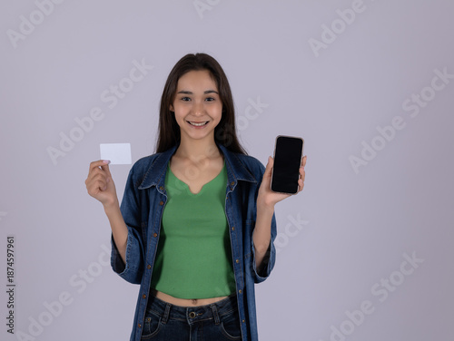 Young woman holding blank card and modern smartphone