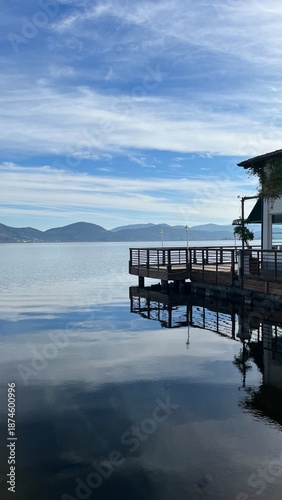 A beautiful view of a lake, with a wooden bridge.