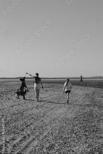 Photography Two girls walking their dogs on the beach at Whiteford point on the Gower coast