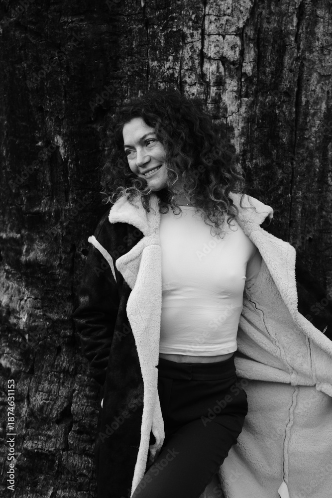Fototapeta premium Woman with curly hair. Black and white portrait. Winter nature