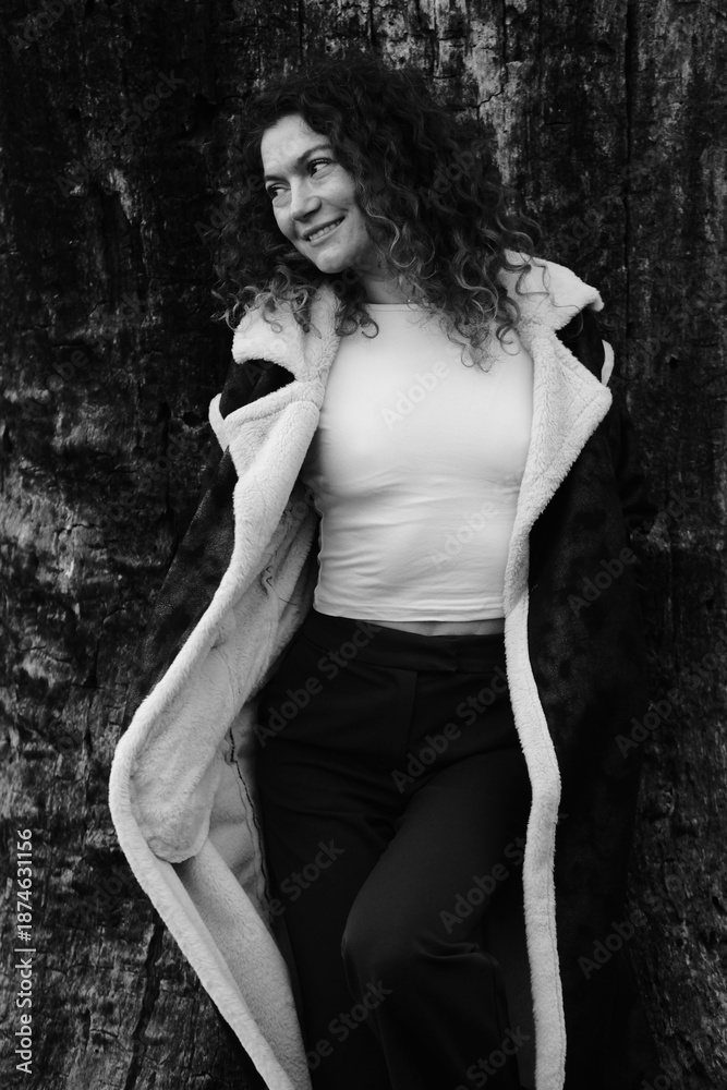 Fototapeta premium Woman with curly hair. Black and white portrait. Winter nature