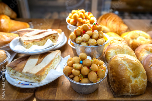 Photos Neapolitan pastiera slices and struffoli cups in a bakery display