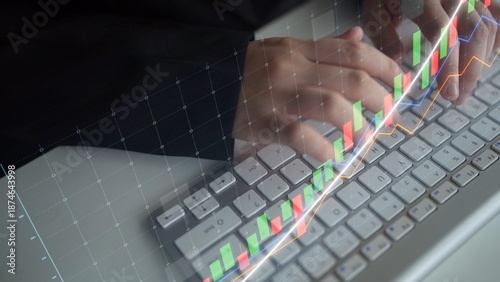 Fotografia A business professional analyzes financial data with stock market graphs displayed over a computer keyboard, capturing the essence of data-driven decision-making