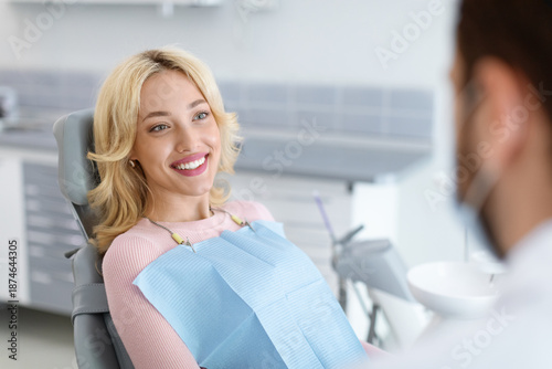 Foto Relaxed blonde woman smiling to her dentist, side view, copy space