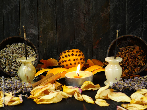 Dried herbs, flowers, pomander, scented candles, and incense sticks placed on a black background. Ingredients for air freshening and relaxation.
 
