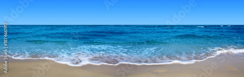 Sandy beach with blue sky and turquoise water .