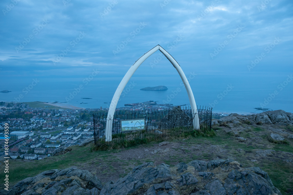 Fototapeta premium Scenic view from North Berwick Law featuring a whale jawbone arch. A historic landmark overlooking the coastal town and breathtaking seascape.