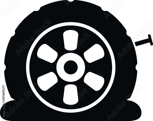 Flat car tire experiencing a puncture from a nail resulting in deflation