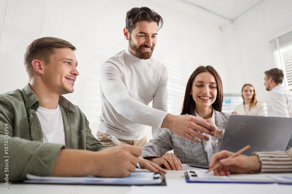Fototapeta premium Businesspeople working together at table in office, low angle view