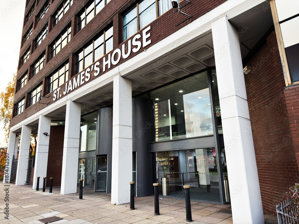 Obraz premium St James House main entrance in Salford UK with glass doors and brick facade