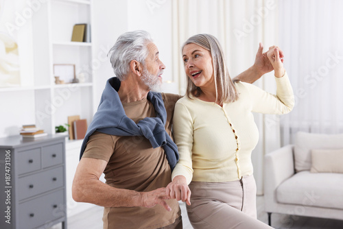 Quadro su tela Lovely senior couple dancing together at home