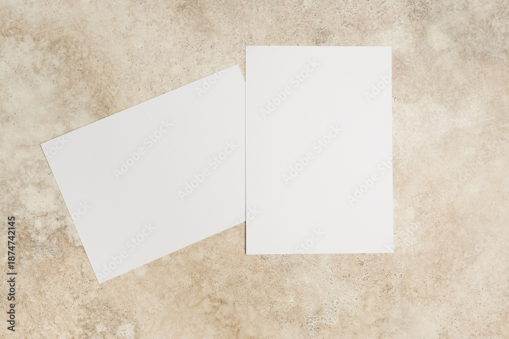 Fototapeta premium Blank invitation card mockup on textured surface, showcasing two cards with ample copy space for customizable designs and creative concepts for various occasions