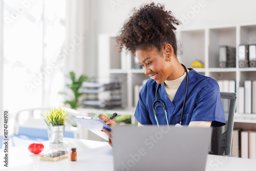 Fotografija Friendly female nurse receptionist answering telephone call, sitting at desk wit