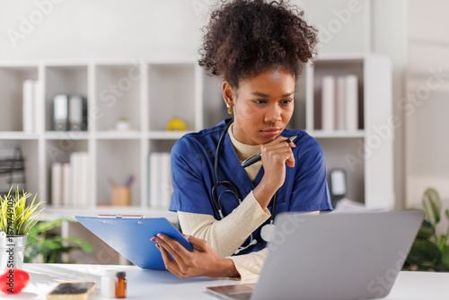 Canvas Print Friendly female nurse receptionist answering telephone call, sitting at desk wit