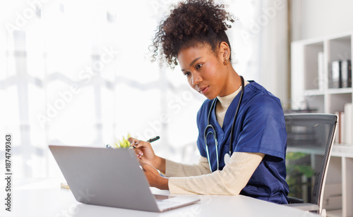 Foto Nurse, young female doctor using laptop online, writing notes in medical journal